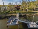 Aerial view of dock and walkway to waterfront home with mature trees at 7897 Russell Creek Dr, Edisto Island, SC 29438