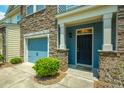 Inviting townhome exterior features stone accents, blue siding, and a charming black front door at 854 Bibury Ct, Charleston, SC 29414