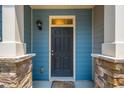 Close up of townhome door with stone accents, blue siding, and a 'hello' welcome mat at 854 Bibury Ct, Charleston, SC 29414