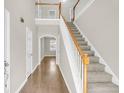 Welcoming foyer with hardwood floors, staircase with white railings, and plenty of natural light at 9253 N Moreto Cir, Summerville, SC 29485