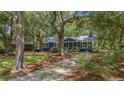 Charming blue home with a well-maintained lawn and mature trees at 10 Chapman Ave, Isle of Palms, SC 29451