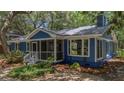 Cozy blue house featuring a screened porch and well-kept landscaping at 10 Chapman Ave, Isle of Palms, SC 29451