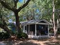 Side view of a blue cottage with a spacious screened porch, perfect for enjoying the outdoors at 10 Chapman Ave, Isle of Palms, SC 29451