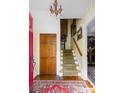 Inviting foyer with hardwood floors, staircase, and elegant chandelier at 1067 Loyalist Ln, Mount Pleasant, SC 29464