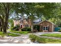 Beautiful two-story brick home with mature trees, manicured lawn, and classic shutters at 1067 Loyalist Ln, Mount Pleasant, SC 29464