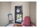 Close-up of the home's inviting front door, featuring a charming wreath and a cozy chair at 112 Worthington Dr, Moncks Corner, SC 29461
