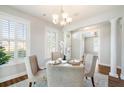 Elegant dining room with neutral colors, plantation shutters, and a modern chandelier at 123 Gaslight Blvd, Summerville, SC 29483