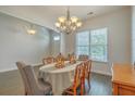 Well-lit dining room showcasing hardwood floors, a chandelier, and a view towards the front entry at 139 Back Tee Cir, Summerville, SC 29485