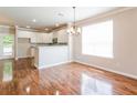 Open dining area with hardwood floors, chandelier lighting, and adjacent white kitchen at 167 Meadow Wood Rd, Summerville, SC 29486