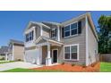 Charming two-story home features a two-car garage, neutral siding, and inviting front porch at 167 Meadow Wood Rd, Summerville, SC 29486