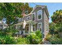 Side view of a charming two-story home with a cozy front porch and colorful landscaping at 171 Queen St, Charleston, SC 29401