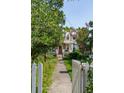 View of a charming two-story home with a cozy front porch, framed by a lush garden and walkway at 171 Queen St, Charleston, SC 29401