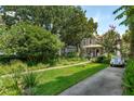 Landscaped front yard leading to a charming two-story home with a inviting front porch at 171 Queen St, Charleston, SC 29401