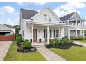 Beautiful home with a covered porch, manicured lawn, and inviting outdoor seating area at 1894 Brittlebush Ln, Johns Island, SC 29455