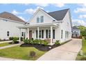 Inviting curb appeal with a classic white exterior, manicured lawn, and a covered front porch at 1894 Brittlebush Ln, Johns Island, SC 29455