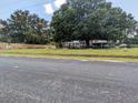 View of a cozy home with a large mature tree, a lawn, and a fence at 205 Indian Field Cir, Saint George, SC 29477