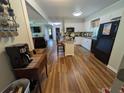Bright kitchen with light wood floors, white cabinets, a center island, and modern appliances at 205 Indian Field Cir, Saint George, SC 29477