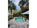 Backyard pool features a brick surround, lounge seating, and tropical landscaping at 2066 Wappoo Dr, Charleston, SC 29412
