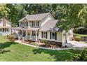 Charming two-story home featuring a spacious porch, manicured lawn, and attached garage at 207 Littlejohn St, Summerville, SC 29483
