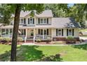 Charming two-story home featuring a spacious porch, manicured lawn, and beautiful landscaping at 207 Littlejohn St, Summerville, SC 29483