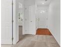 Hallway with white doors, neutral carpeting, and wood floors at the entryway at 210 Wildberry Ln, Goose Creek, SC 29445