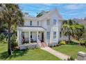 Inviting two-story home with a front porch, manicured lawn, and a stone walkway at 216 Freeman St, Mount Pleasant, SC 29464