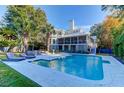 Gorgeous backyard showcasing a pristine pool, lounge chairs, and lush greenery, perfect for relaxation at 2414 Goldbug Ave, Sullivans Island, SC 29482