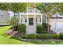 Inviting two-story home with a charming porch, lush landscaping, and a well-manicured front lawn at 3028 River Vista Drive Way, Mount Pleasant, SC 29466