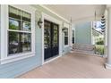Charming front porch features a swing, black double doors, exterior lights, and decorative architectural details at 3028 River Vista Drive Way, Mount Pleasant, SC 29466