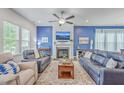 Comfortable living room with a fireplace, ceiling fan, and stylish blue couches on a decorative rug at 312 Cypress Knee Landing, Summerville, SC 29483