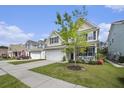 Charming two-story home with a well-manicured lawn, inviting front porch, and a two-car garage at 317 Whispering Breeze Ln, Summerville, SC 29486