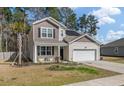 Inviting two-story home with a manicured front yard, a two-car garage, and energy-saving solar panels at 324 Spruce Ivy St, Moncks Corner, SC 29461