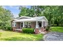 Inviting brick home with a metal roof, rocking chair front porch, and green lawn at 416 Altman St, Moncks Corner, SC 29461
