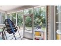 View of the screened-in porch with an outdoor grill and a view of the wooded backyard at 4969 Franconia Dr, Summerville, SC 29485