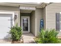 Close-up of the front entry with a decorative door, house number, and lush landscaping at 519 Tarleton Dr, Summerville, SC 29483