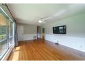 Spacious living room with hardwood floors, large windows, and a wall-mounted TV for entertainment at 7 Plainfield Dr, Charleston, SC 29407