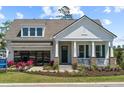Charming two-story home boasts a manicured lawn, inviting porch, and modern garage at 727 Breakers Reef Ln, Huger, SC 29450