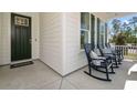 Inviting front porch with rocking chairs offers a relaxing outdoor space at 727 Breakers Reef Ln, Huger, SC 29450