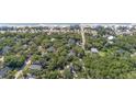 A scenic aerial view captures a house nestled among trees near a beach, marked with a yellow pin for location at 817 Cheehaw St, Edisto Island, SC 29438