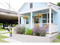 Charming exterior of home with light blue siding, white trim, and flowering plants at 10 Riker St, Charleston, SC 29403