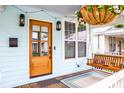 Inviting front porch with hanging plants, lights and a swing at 10 Riker St, Charleston, SC 29403