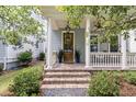 Inviting front porch with brick steps, white columns, and a craftsman style front door at 1052 Avenue Of Oaks, Charleston, SC 29407