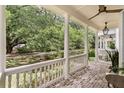 Covered front porch showcasing brick flooring, classic white columns, and peaceful neighborhood views at 1052 Avenue Of Oaks, Charleston, SC 29407