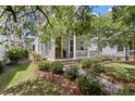 Beautifully landscaped yard with a craftsman-style home featuring a welcoming front porch with white columns at 1052 Avenue Of Oaks, Charleston, SC 29407