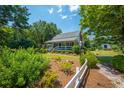 Inviting white home surrounded by lush greenery, featuring a quaint front porch at 1133 Highway 311, Cross, SC 29436