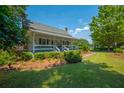 Charming home featuring a covered front porch, white railings, and lush landscaping at 1133 Highway 311, Cross, SC 29436