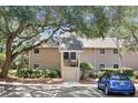 Inviting exterior of a tan condo building with stairs to the second-floor entry under mature tree canopy at 146 High Hammock Villas, Seabrook Island, SC 29455
