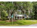 View of brick home with moss draped trees on a large grassy lawn at the corner of two streets at 1789 Balfoure Dr, Charleston, SC 29407