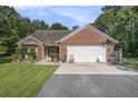 Inviting brick home with a spacious two-car garage, complemented by a beautifully landscaped front yard at 214 Deer Ridge Court Ct, Huger, SC 29450