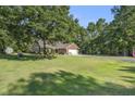 Expansive front yard featuring lush lawn, mature trees, and a charming house with a long driveway at 214 Deer Ridge Court Ct, Huger, SC 29450